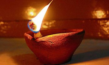 விநாயகரின் படத்திற்கு முன்பு ஒரு மண் அகல் விளக்கு.